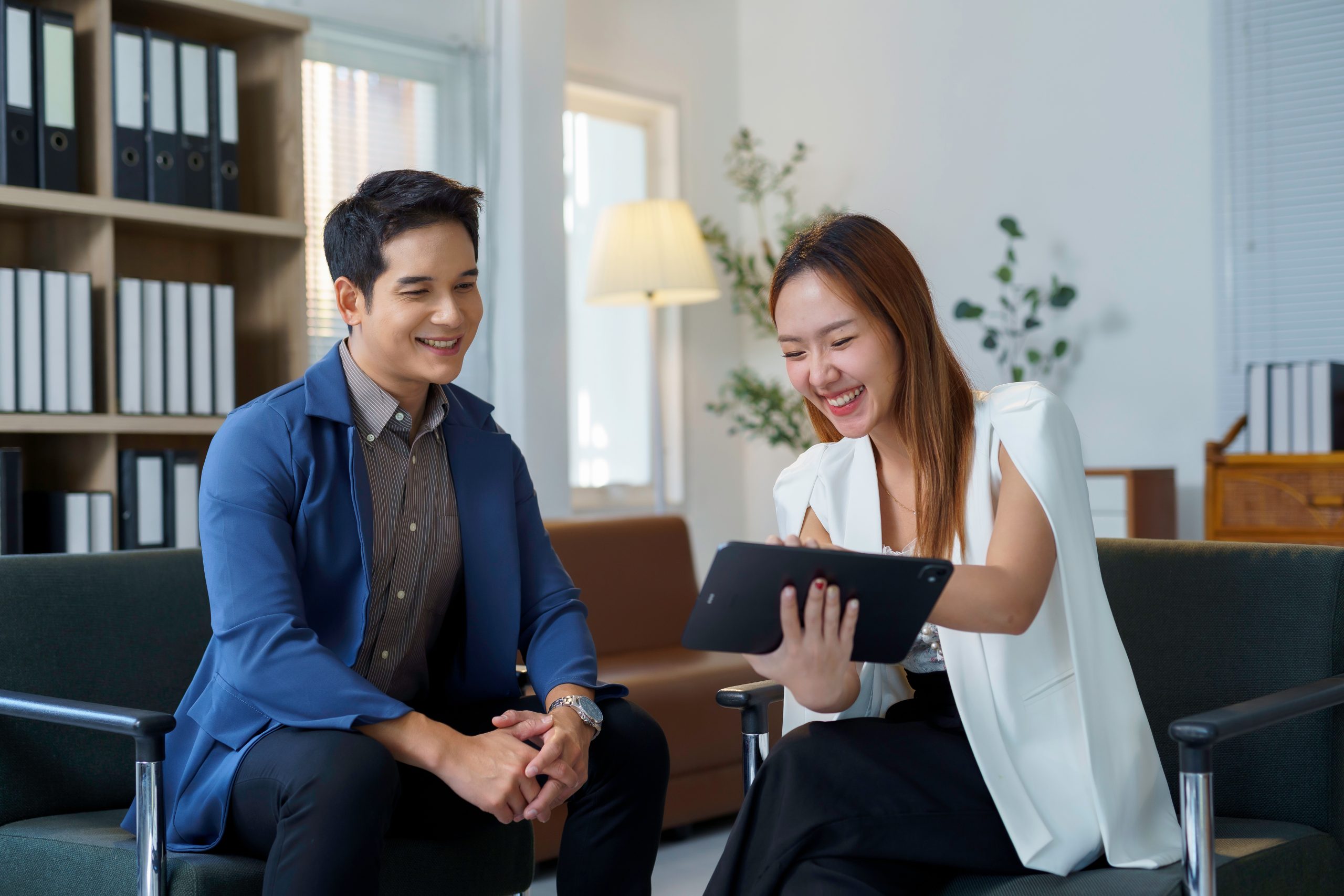 Two business people talking and looking at a tablet